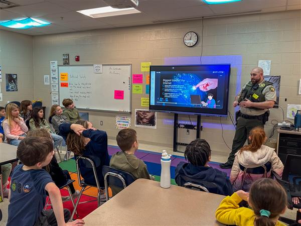 police officer talking to class of students